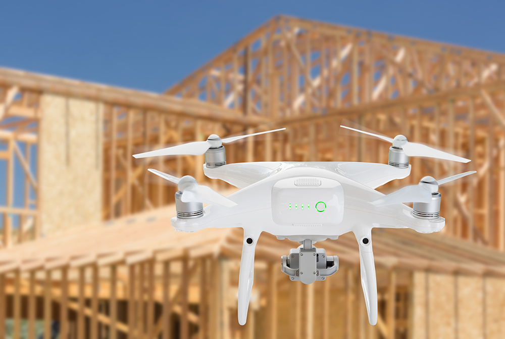Unmanned Aircraft System (UAV) Quadcopter Drone In The Air Over Construction Site.